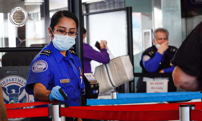 Transportation Security Administration (TSA) workers screen passengers at O'Hare International Airport in Chicago on Nov. 8, 2021. (Scott Olson/Getty Images)