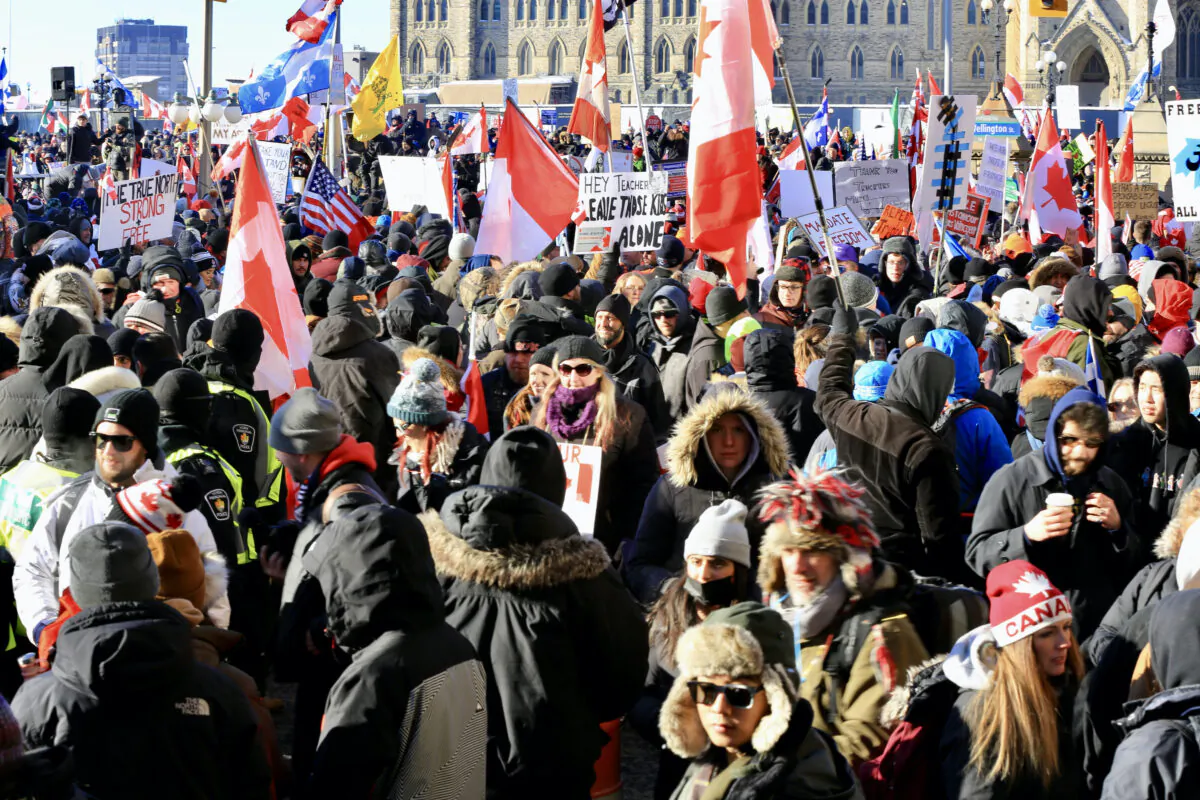 People gather on Parliament Hill as the trucker convoy protesting COVID-19 mandates and restrictions stages demonstrations in Ottawa on Jan. 29, 2022. (Jonathan Ren/The Epoch Times)