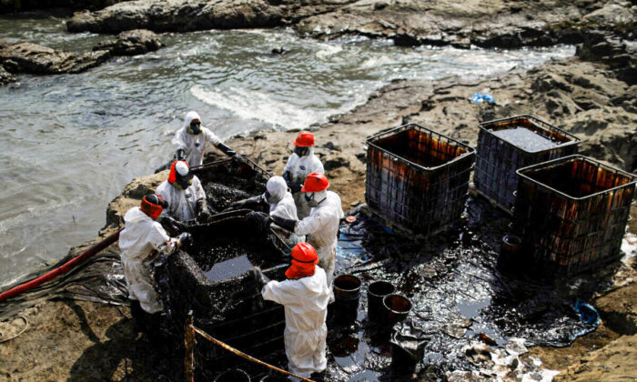 Workers clean up an oil spill following an underwater volcanic eruption in Ventanilla, Peru, on Jan. 25, 2022. (Pilar Olivares/Reuters)