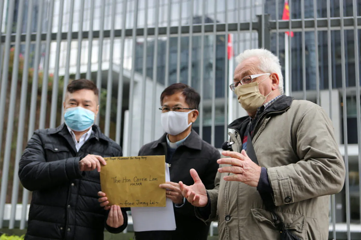 The catholic priest Franco Mella (R) talks to the media before delivering a letter addressed to Hong Kong Chief Executive Carrie Lam, calling on authorities to drop charges against media mogul Jimmy Lai and other political activists jailed or in custody under the national security law, outside the government headquarters in Hong Kong, on Jan. 31, 2022. (James Pomfret/Reuters)
