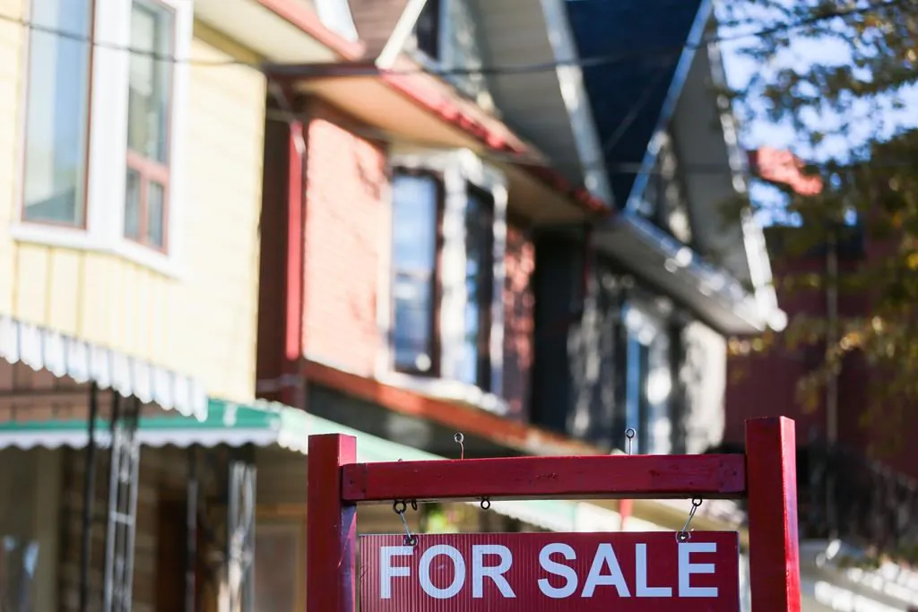 A for sale sign is displayed in front of a house in the Riverdale area of Toronto on Sept. 29, 2021. (Evan Buhler/The Canadian Press)