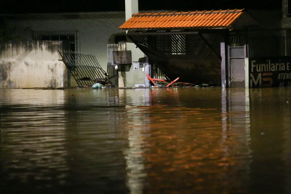 A gate of a house is seen broken by flooding after heavy rains in Caieiras, Brazil, on Jan. 30, 2022. (Carla Carniel/Reuters)