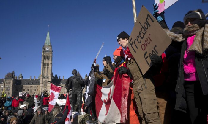 Protesters stand on the back of a truck during the Freedom Convoy demonstrations against COVID-19 vaccine mandates and other restrictions on Parliament Hill in Ottawa on Jan. 29, 2022. (Adrian Wyld/The Canadian Press)