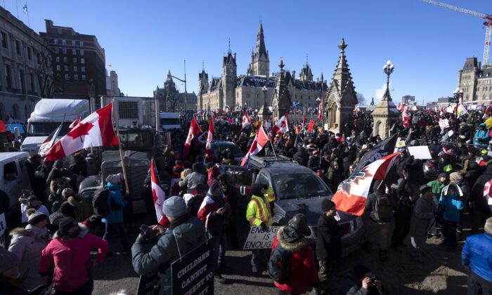 Protesters gather on Wellington St. in front of the Parliament Buildings as they participate in a Freedom Convoy protest against COVID-19 vaccine mandates and other restrictions, in Ottawa, on Jan. 29, 2022. (Adrian Wyld/The Canadian Press)