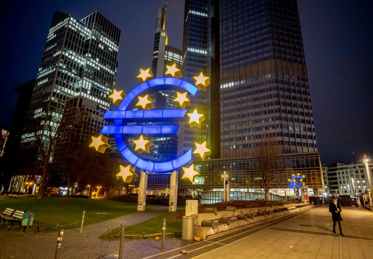 A man walks past the Euro sculpture in Frankfurt, Germany, on March 11, 2021. (Michael Probst/AP Photo)