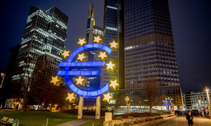A man walks past the Euro sculpture in Frankfurt, Germany, on March 11, 2021. (Michael Probst/AP Photo)