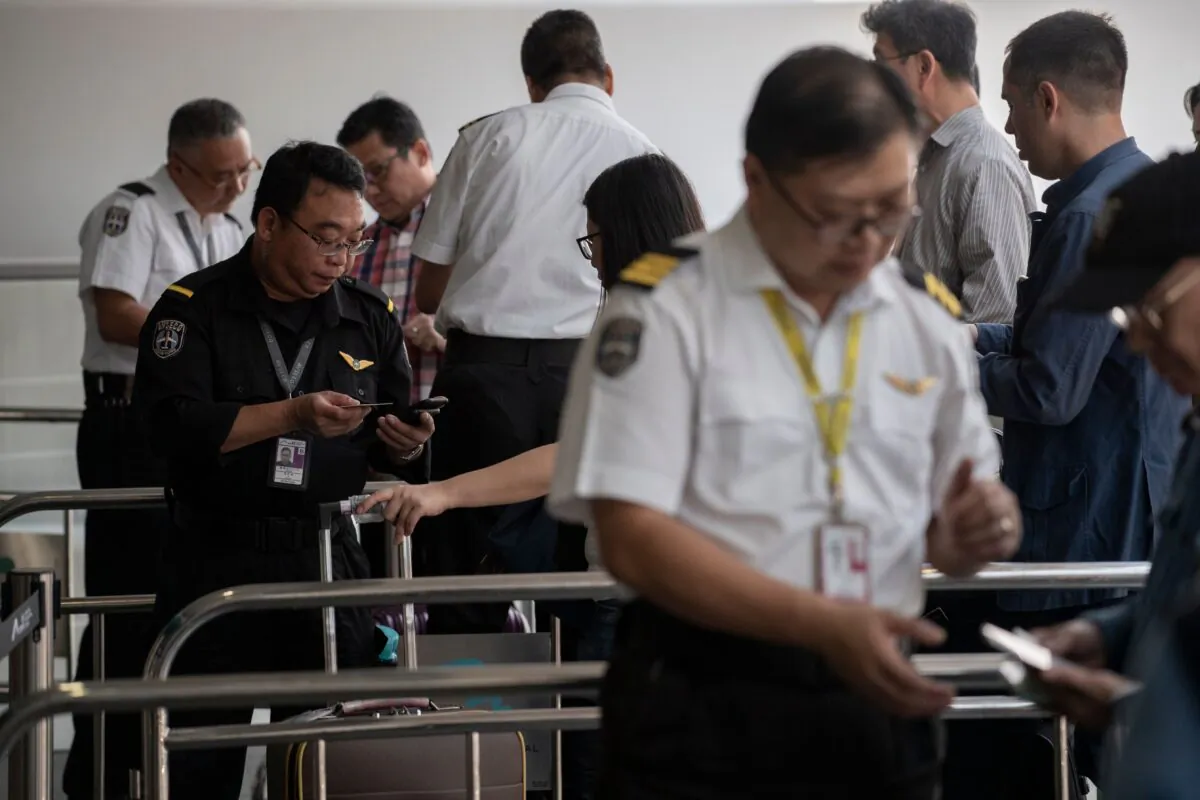 Security officers check boarding passes and passports of passengers at the international airport in Hong Kong on September 22, 2019. (Nicolas Asfouri/AFP via Getty Images)