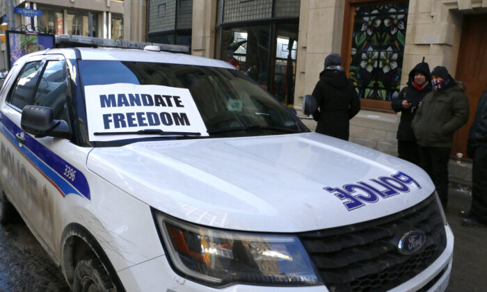 A sign is placed on a patrol SUV from the Ottawa Police on Metcalfe St. during protests in Ottawa on Jan. 29, 2022. (Noé Chartier/The Epoch Times)