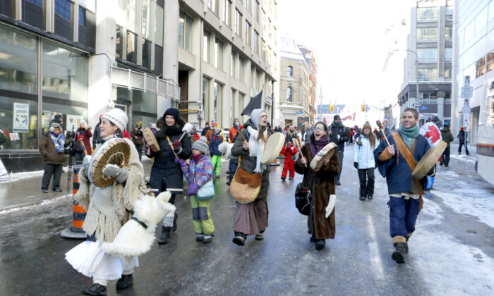 Protesters perform with drums as they walk away from Parliament Hill in Ottawa on Jan. 29, 2022. (Noé Chartier/The Epoch Times)