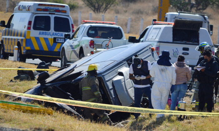 At the scene of the accident, rescue workers, including forensic scientists and firefighters, are working next to a damaged vehicle after a van has fallen into a ditch on a central Mexican highway near the city of Lagos de Moreno, Mexico.  , January 29, 2022.  (Liberto Urena / Reuters)