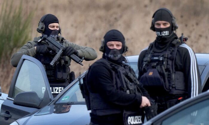 Police officers prepare for an operation close to a road where two police officers were shot during a traffic stop near Kusel, Germany, on Jan. 31, 2022. (Michael Probst/AP Photo)