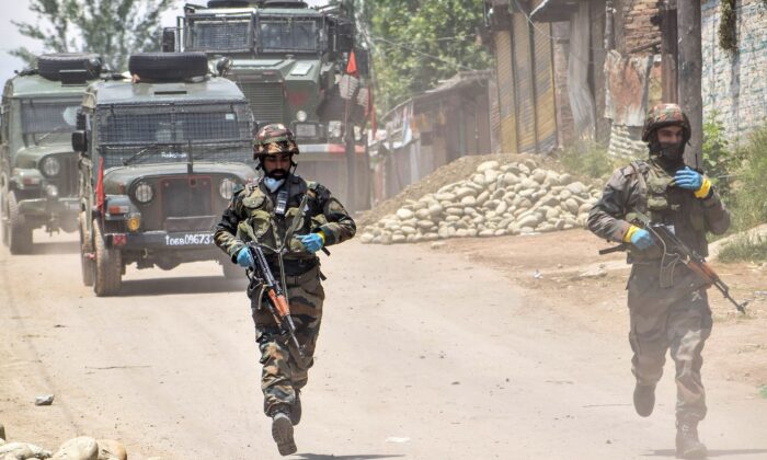 Security personnel run patrolling near the site of a gunbattle in Kangan area of south Kashmir's Pulwama district on June 3, 2020. At least three alleged Jaish-e-Mohammed terrorists were killed during a gunbattle with security personnel on June 3 at Kangan village of Pulwana district, local media reported. (STR/AFP via Getty Images)