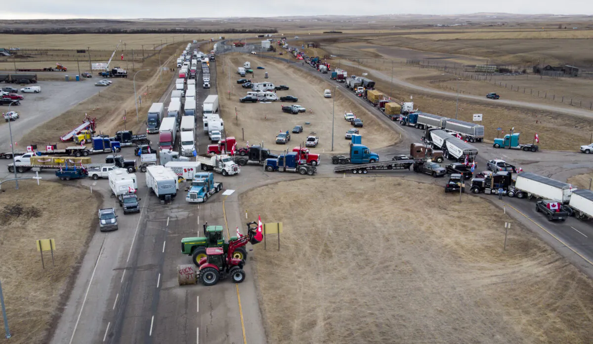 Anti-mandate demonstrators gather as a truck convoy blocks the highway to the busy U.S. border crossing in Coutts, Alta., on Jan. 31, 2022. (Jeff McIntosh/The Canadian Press)