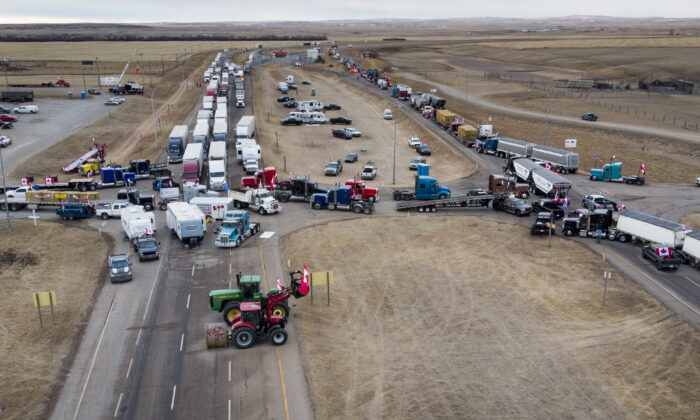 Anti-mandate demonstrators gather as a truck convoy blocks the highway to the busy U.S. border crossing in Coutts, Alta., on Jan. 31, 2022. (Jeff McIntosh/The Canadian Press)