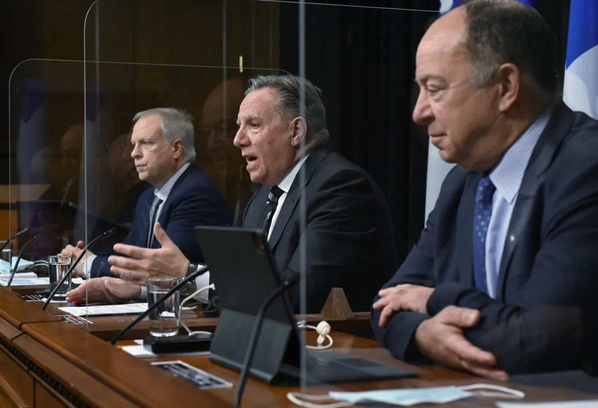 Quebec Premier Francois Legault, centre, speaks during a news conference on the COVID-19 pandemic, Feb. 1, 2022, at the legislature in Quebec City. Legault is flanked by Luc Boileau, Quebec interim director of National Public Health, left, and Quebec Health Minister Christian Dube. Francois Legault says he is abandoning his threat to tax the unvaccinated. (The Canadian Press/Jacques Boissinot)