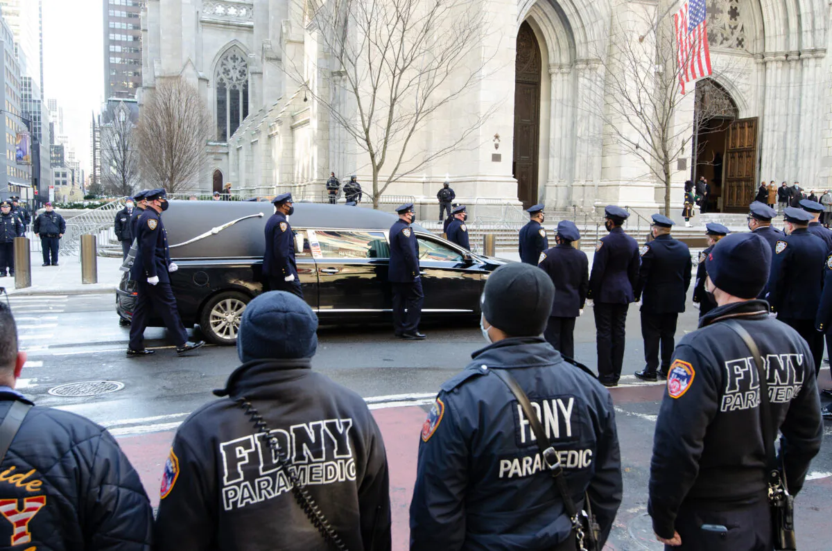 The hearse containing the casket of fallen NYPD policeman Wilbert Mora approaches St. Patrick’s Cathedral for his wake on Feb. 1, 2022. (Dave Paone/The Epoch Times)