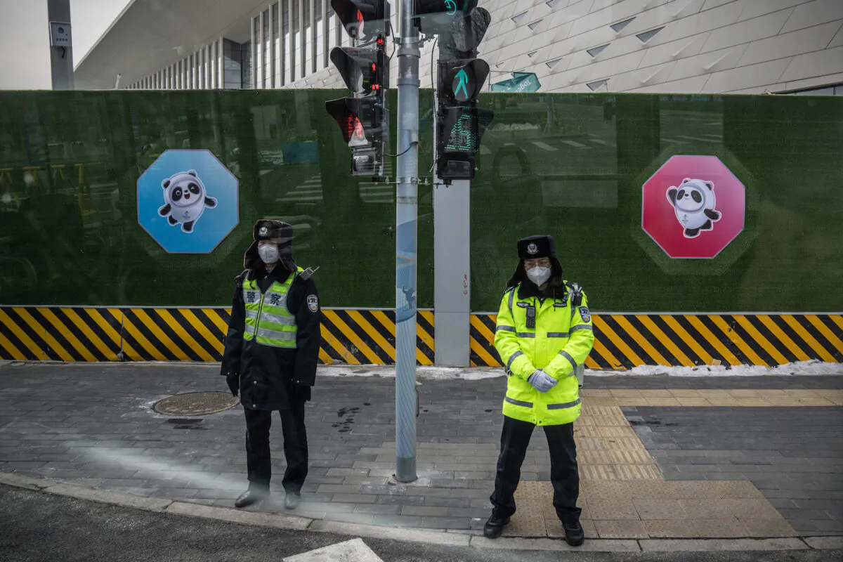 Police officers are pictured through a bus window as they guard the perimeter fence of the Winter Olympics closed loop system on Jan. 26, 2022, in Beijing, China. (Carl Court/Getty Images)