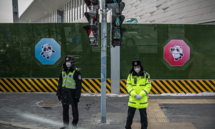 Police officers are pictured through a bus window as they guard the perimeter fence of the Winter Olympics closed loop system on Jan. 26, 2022, in Beijing, China. (Carl Court/Getty Images)