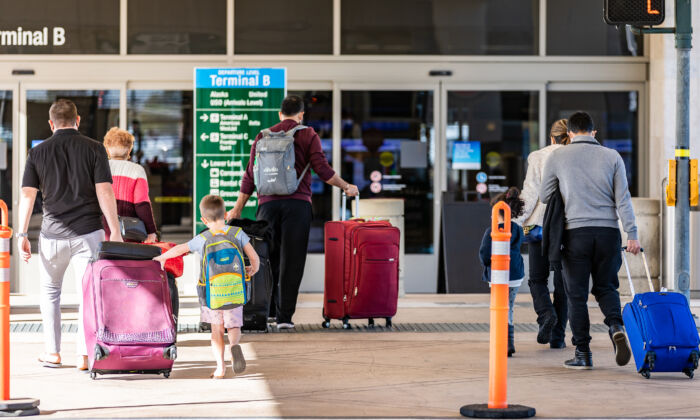 Travelers walk with  baggage at John Wayne Airport, in Santa Ana, Calif., on Dec. 30, 2020. (John Fredricks/The Epoch Times)