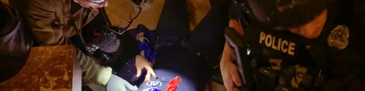 A photographer and police officer give first aid to Ashli Babbitt on Jan. 6, 2021. The man at left was once wanted by the FBI. (Video Still/Sam Montoya for The Epoch Times)