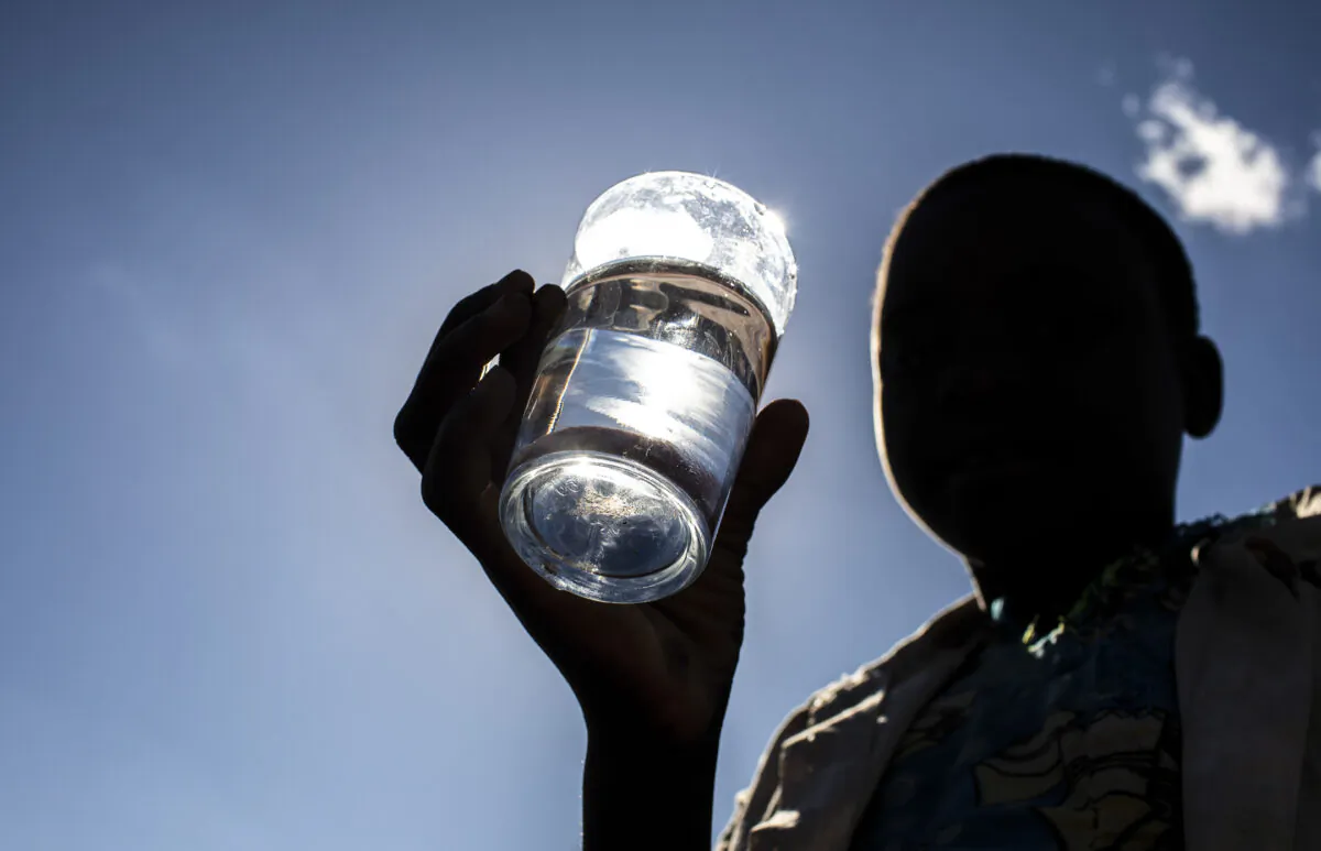 A child drinks clean water from a well built by Water Wells For Africa in Eastern Malawi on June 17, 2017. (John Fredricks/The Epoch Times)