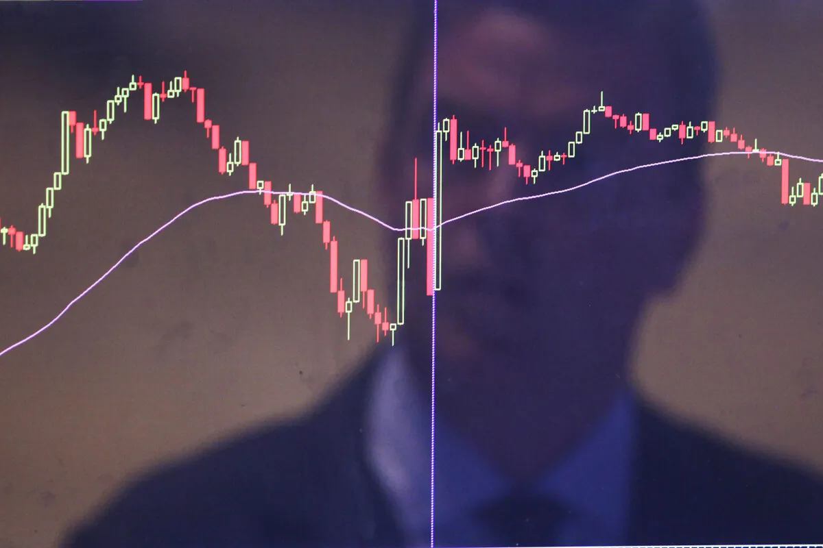 A trader is reflected in a market screen on the floor of the New York Stock Exchange (NYSE) in New York, on Aug. 25, 2015. (Spencer Platt/Getty Images)