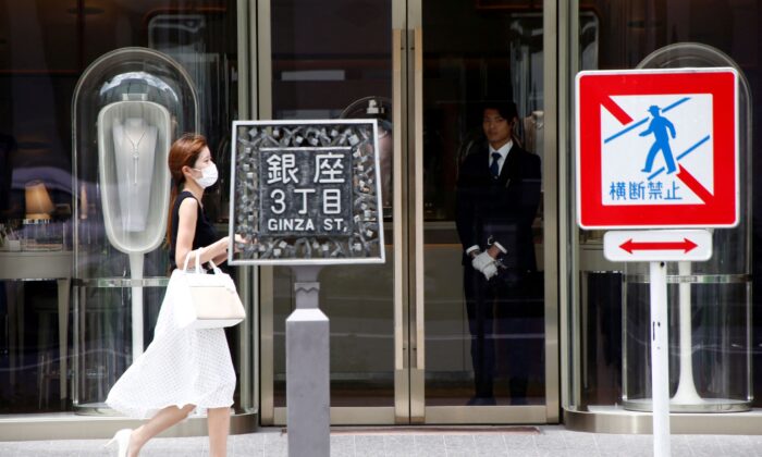 A woman walks past a luxury brand shop at a shopping district in Tokyo, Japan, on July 4, 2018. (Kim Kyung-Hoon/Reuters)