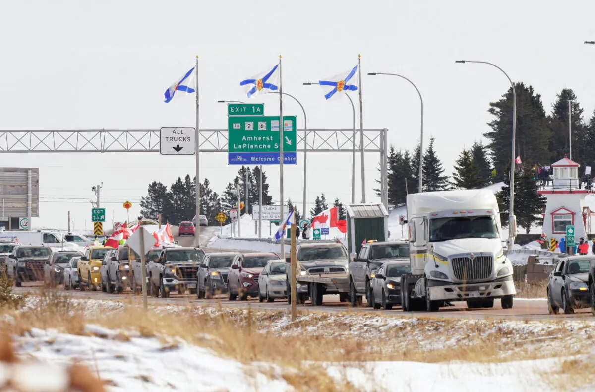 Truck drivers and supporters heading to Ottawa to demonstrate against vaccine mandates travel on the Nova Scotia-New Brunswick provincial boundary in Fort Lawrence, Nova Scotia, on Jan. 23, 2022. (John Morris/Reuters)