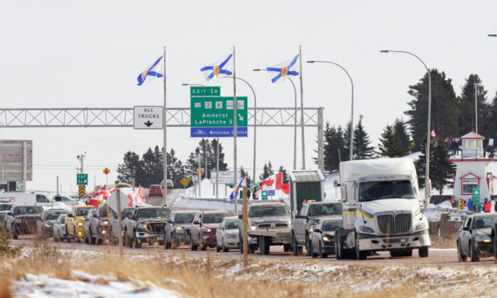 Truck drivers and supporters heading to Ottawa to demonstrate against vaccine mandates travel on the Nova Scotia-New Brunswick provincial boundary in Fort Lawrence, Nova Scotia, on Jan. 23, 2022. (John Morris/Reuters)