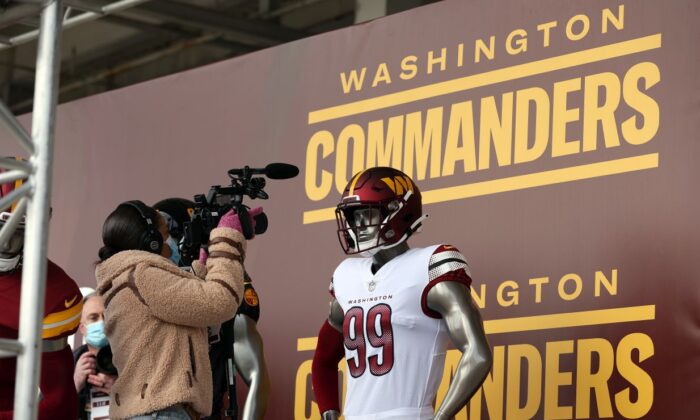 Members of the media take pictures and video of the new uniforms during the announcement of the Washington Football Team's name change to the Washington Commanders at FedExField in Landover, Md. on Feb. 2, 2022. (Rob Carr/Getty Images)