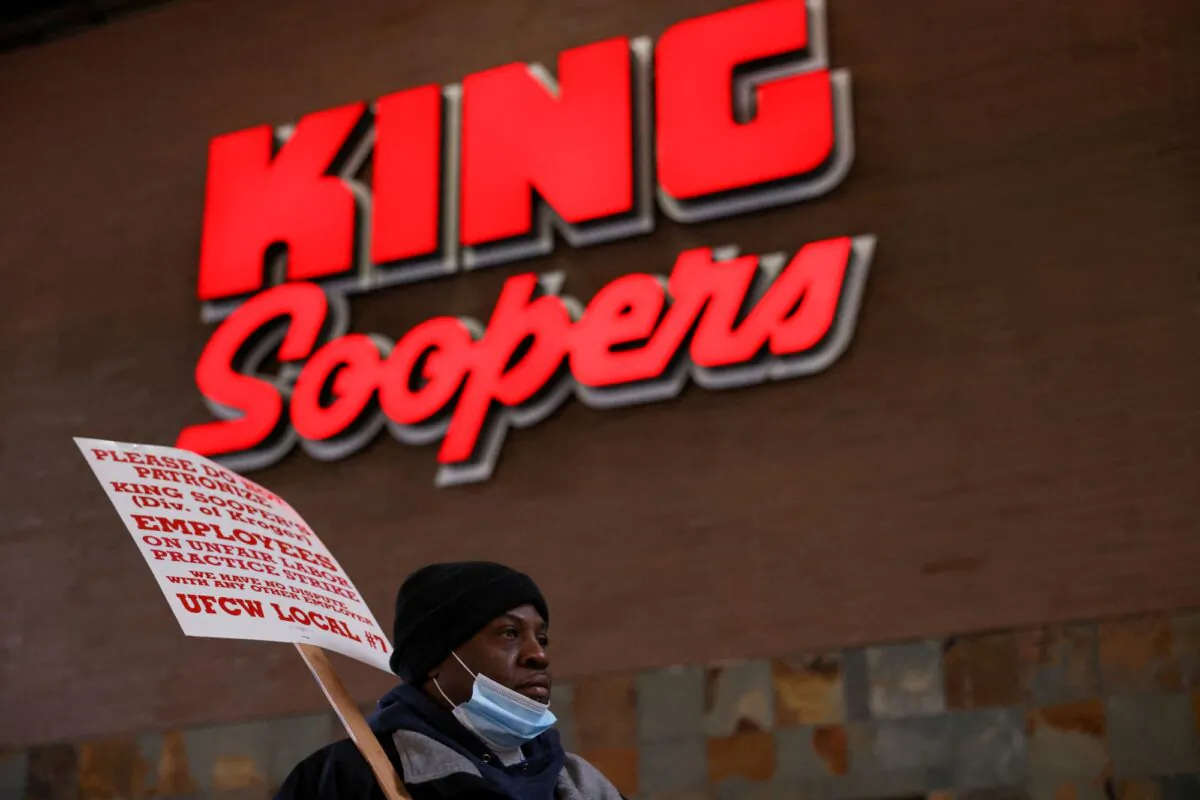 A union member raises a sign outside a Kroger's King Soopers store during a protest as workers go on strike in Denver, on Jan. 12, 2022. (Kevin Mohatt/Reuters)