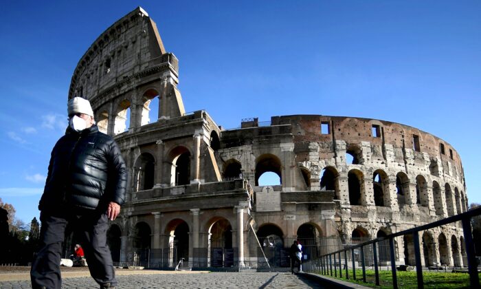 A face masked man walks by the ancient Colosseum in downtown Rome on Dec. 5, 2020. (Filippo Monteforte/AFP via Getty Images)