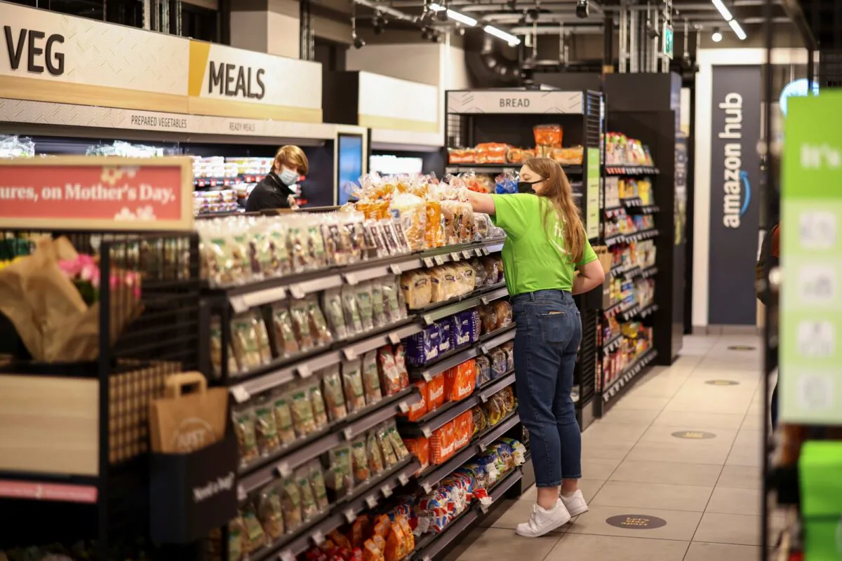 A staff member arranges products at the UK's first Amazon Fresh supermarket in London, on March 4, 2021. (Henry Nicholls/Reuters)