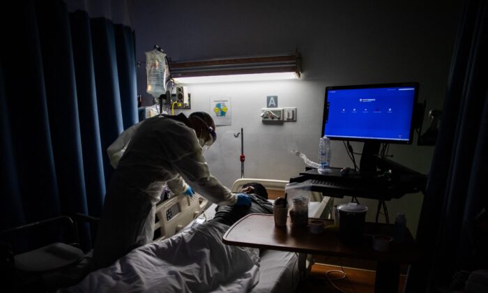 A doctor checks on a COVID-19 patient in a hospital in Los Angeles County, Calif., in a file photograph. (Apu Gomes/AFP via Getty Images)