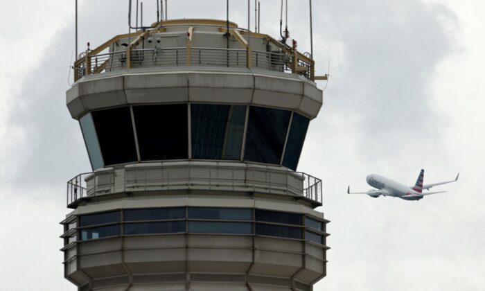 A plane passes the air traffic control tower at Ronald Reagan Washington National Airport in Arlington, Va., on June 5, 2017. (Kevin Lamarque/Reuters)