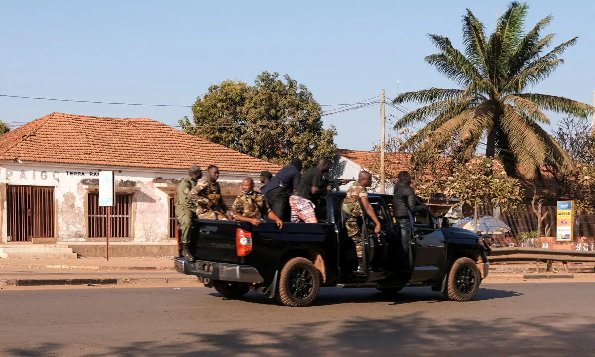 Armed soldiers move on the main artery of the capital after heavy gunfire around the presidential palace in Bissau, Guinea Bissau, on Feb. 1, 2022. (Reuters/Stringer)