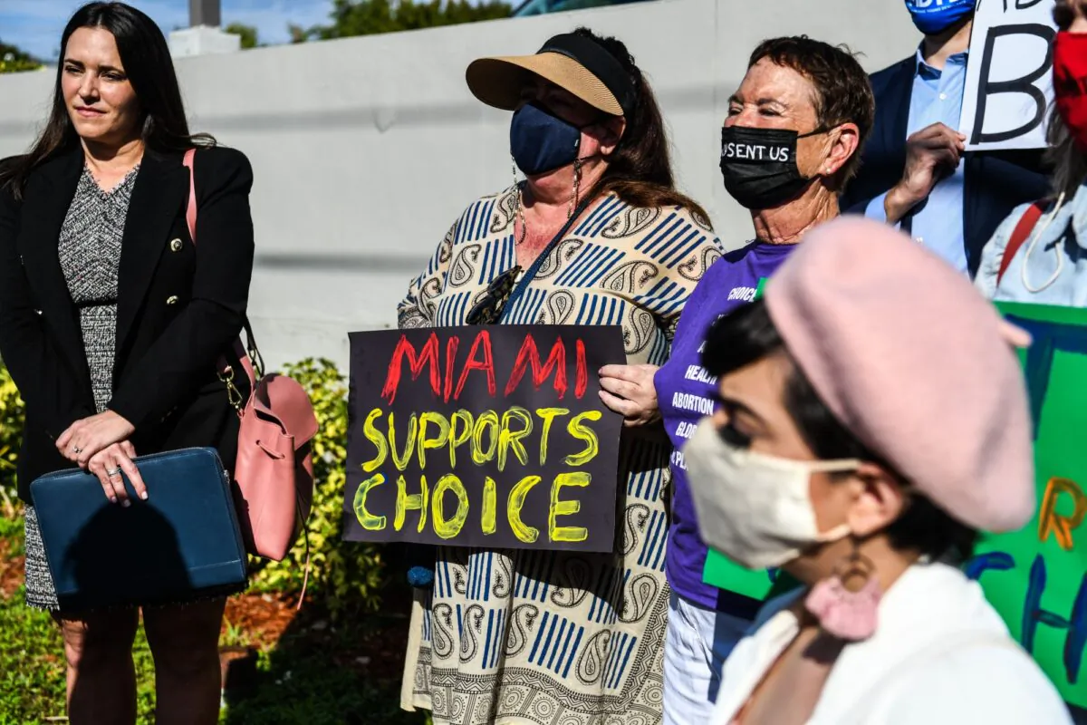 People hold placards as they protest against Florida's 15-week abortion ban in front of the office of State Senator Ileana Garcia, in Coral Gables, Fla., on Jan. 21, 2022. (Chandan Khanna/AFP via Getty Images)