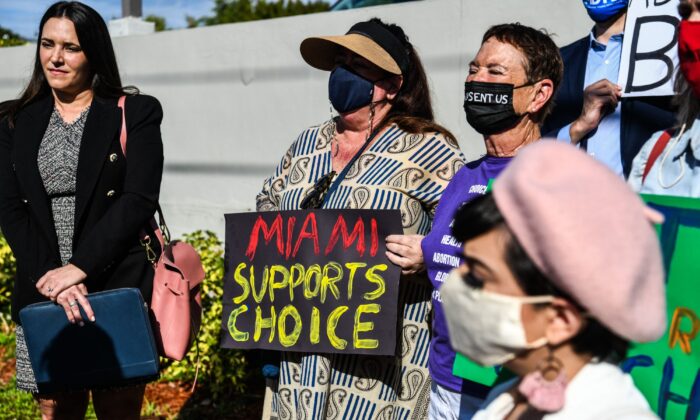 People hold placards as they protest against Florida's 15-week abortion ban in front of the office of State Senator Ileana Garcia, in Coral Gables, Fla., on Jan. 21, 2022. (Chandan Khanna/AFP via Getty Images)