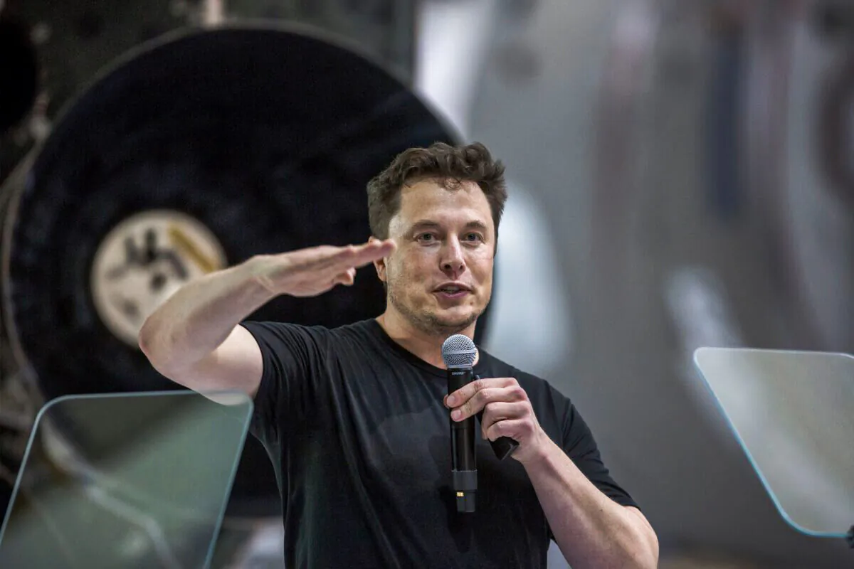 Elon Musk speaks near a Falcon 9 rocket at the SpaceX headquarters and rocket factory in Hawthorne, Calif., on Sept. 17, 2018. (David McNew/AFP via Getty Images)