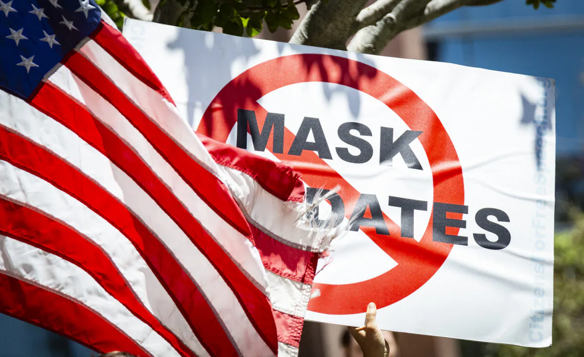 A protester holds a sign against mask mandates in Costa Mesa, Calif., on June 10, 2021. (John Fredricks/The Epoch Times)