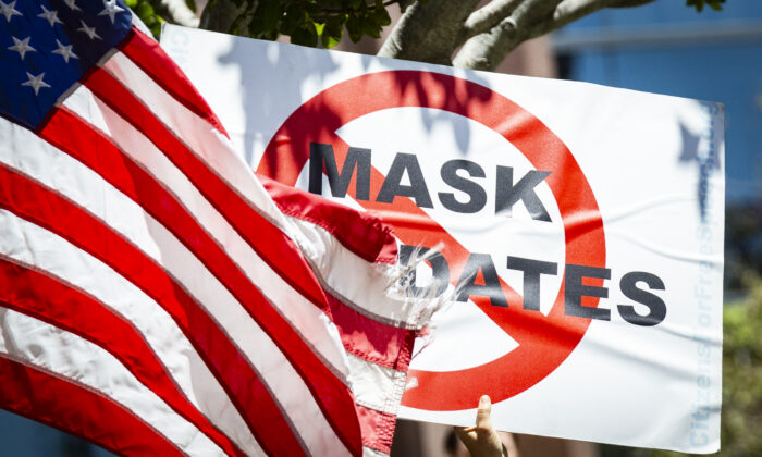A protester holds a sign against mask mandates in Costa Mesa, Calif., on June 10, 2021. (John Fredricks/The Epoch Times)