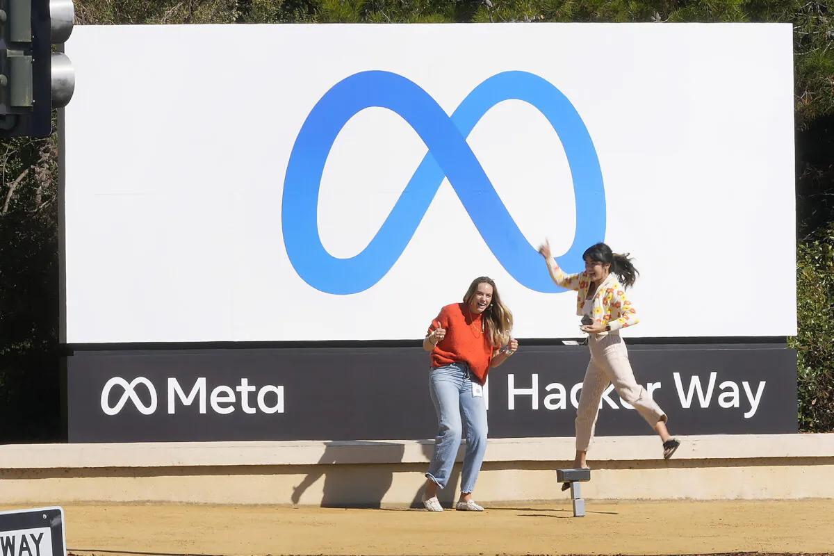Facebook employees take a photo with the company's new name and logo outside its headquarters in Menlo Park, Calif., on Oct. 28, 2021. (Tony Avelar/AP Photo)