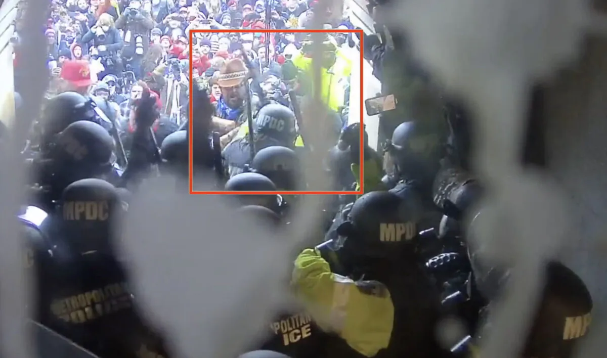 A Metropolitan Police Department officer raises her baton before striking Rosanne Boyland outside the West Terrace tunnel at the U.S. Capitol. (Video Still/U.S. Department of Justice)