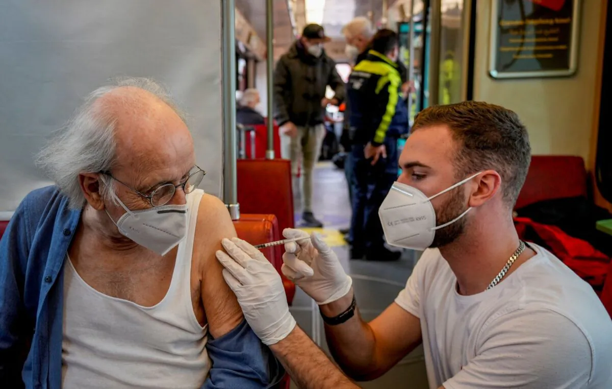 A 85-year-old man receives a booster vaccination in the so called "vaccination express" tram in central Frankfurt, Germany, on Nov. 4, 2021. (Michael Probst/AP Photo)
