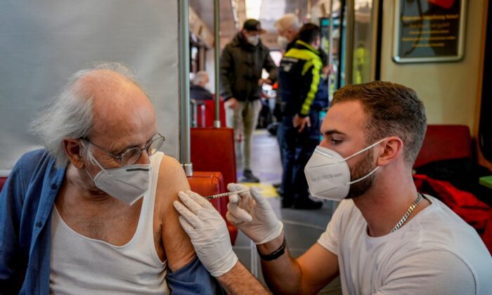 A 85-year-old man receives a booster vaccination in the so called "vaccination express" tram in central Frankfurt, Germany, on Nov. 4, 2021.   (Michael Probst/AP Photo)