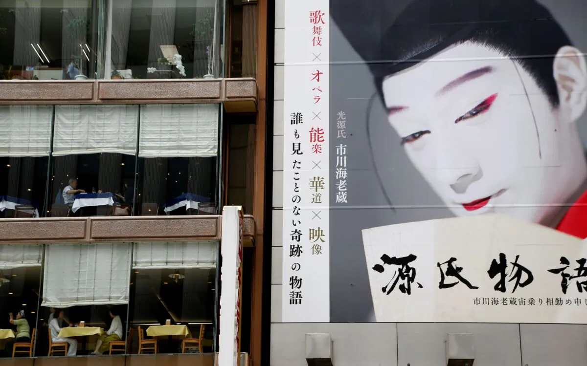 Customers have lunch at restaurants next to a record shop which has a large poster on its wall in Tokyo, Japan, on July 4, 2018. (Kim Kyung-Hoon/Reuters)