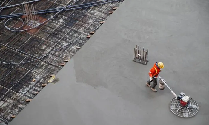 A worker smooths concrete at a construction site in Toronto, Jan. 16, 2020. (The Canadian Press/Cole Burston)