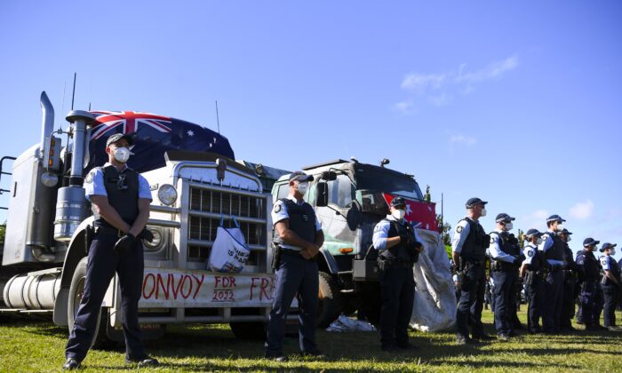 Police officers guard a truck as protesters are being moved on from makeshift camp next to the National Library in Canberra, Australia, on Feb. 4, 2022. A camp of protesters in Canberra has been given a move on order by police. (AAP Image/Lukas Coch) 