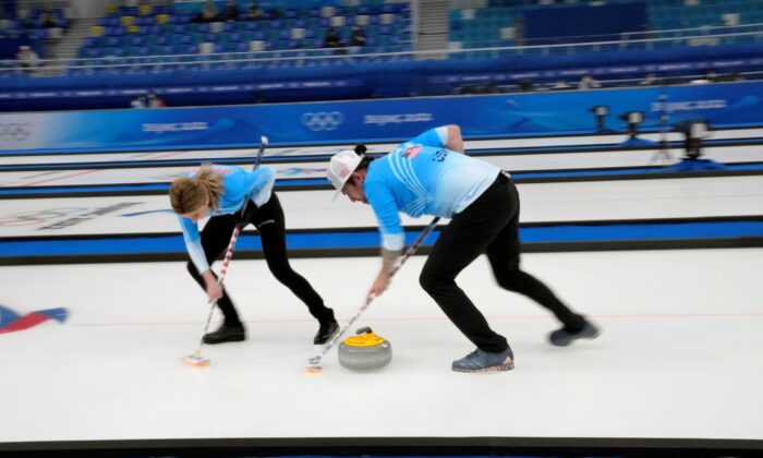 Christopher Plys and Victoria Persinger of the United States sweep the ice, during the mixed doubles curling match against Sweden, at the 2022 Winter Olympics in Beijing, on Feb. 4, 2022. (Nariman El-Mofty/AP Photo)
