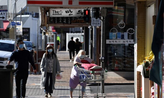 People wearing face masks walk through the quiet streets of the Strathfield suburb of Sydney on August 11, 2021, as the city's more than five million people are enduring their seventh week under stay-at-home orders. (Saeed Khan/AFP via Getty Images)